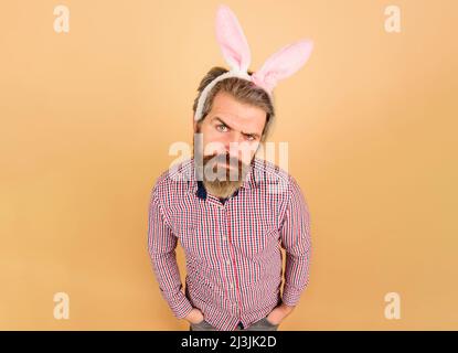 Osterfest. Ernsthafter bärtiger Mann in Hasenohren. Rabbit guy. Osterparty. Stockfoto