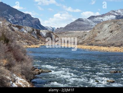 Shoshone River mit Blick auf den Yellowstone National Park von Cody, WY. Wasserrausch im Frühling aufgrund von schmelzendem Schnee in den Bergen. Auch Fischer. Stockfoto