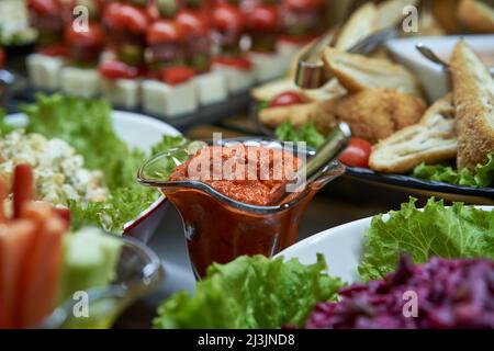 Aivar-Sauce im Hintergrund mit einer weiteren Mahlzeit auf dem Tisch Stockfoto