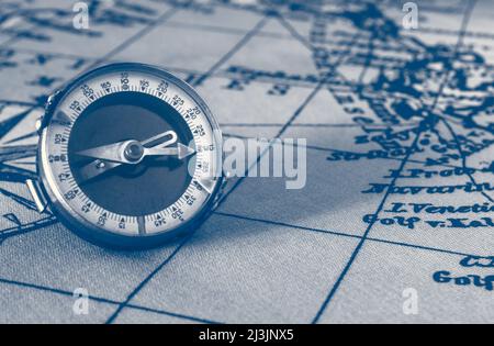 Magnetische alte Kompass auf Welt vintage Karte.Reisen, Geographie, Navigation, Tourismus und Exploration Konzept Hintergrund.Makro-Aufnahme, flacher Fokus. Stockfoto