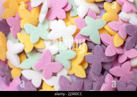 Bunte Schmetterlinge, beliebte Zuckerkonditorei Streuseln, solide Hintergrund. Stockfoto