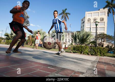 Mehrere Jungen spielen Fußball (Futbol, Fußball) auf einer Straße in Havanna, Kuba; Havanna, Kuba Stockfoto