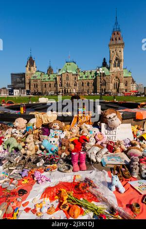 Schuhe und Spielzeuge, die in der Nähe der Centennial Flame auf Parliament Hill in Gedenken an die Kinder, die starben und in einer Wohnschule begraben gefunden wurden... Stockfoto