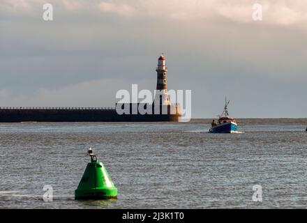 Leuchtturm am Ende des Roker Pier mit Boot und Boje im Wasser; Sunderland, Tyne und Wear, England Stockfoto
