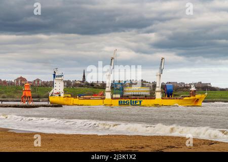 Frachtschiff und Herde Groyne Lighthouse am Littlehaven Beach in South Shields; South Shields, Tyne und Wear, England Stockfoto