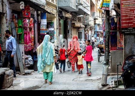 Mutter und Kinder gehen zusammen die traditionelle Straße in Indien entlang; Indien Stockfoto