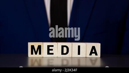 Medienwort auf Holzblock geschrieben. Medien Motivation Text auf Holzblöcke Business-Konzept weißen Hintergrund. Vorderansicht Konzepte, Blume im Hintergro Stockfoto