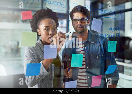 Zwei Köpfe sind effektiver als einer. Eine Aufnahme von Mitarbeitern, die in einem modernen Büro Brainstorming durchführen. Stockfoto