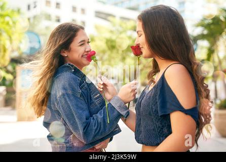 Du mein Lieblingsmensch auf der ganzen Welt. Eine kurze Aufnahme von zwei weiblichen besten Freundinnen, die in der Stadt Rosen riechen. Stockfoto