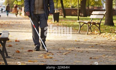 Alter kaukasischen Blinden Mann verwendet einen Stock, um im Park fallen selektive Fokus Kopie Raum zu gehen. Hochwertige Fotos Stockfoto