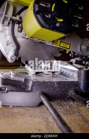 Arbeiter schneidet die Schonplatte an der Kreissäge vor dem Einbau. Stockfoto