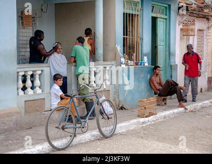 In einem Friseurladen auf der Veranda eines Hauses und neben einem Lebensmittelgeschäft in Trinidad, Kuba, ist vieles los. Stockfoto