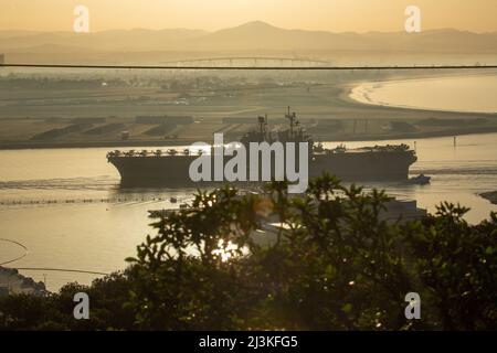 Die USS Tripoli (LHA-7), ein amphibisches Angriffsschiff der amerikanischen Klasse, kehrt am 7. April 2022 in den Hafen der Naval Air Station North Island, Kalifornien, zurück. Die Tripolis unterstützte den Betrieb von 20 F-35B Lightning II-Jets von Marine Fighter Attack Squadrons 211 und 225, Marine Aircraft Group 13, 3. Marine Aircraft Wing sowie Marine Operational Test and Evaluation Squadron im Rahmen der Lightning Carrier Concept Demonstration des U.S. Marine Corps. Die Lightning Carrier Concept Demonstration zeigt, dass Tripolis und andere amphibische Angriffsschiffe in der Lage sind, als dedizierte stationäre Plattformen zu arbeiten Stockfoto