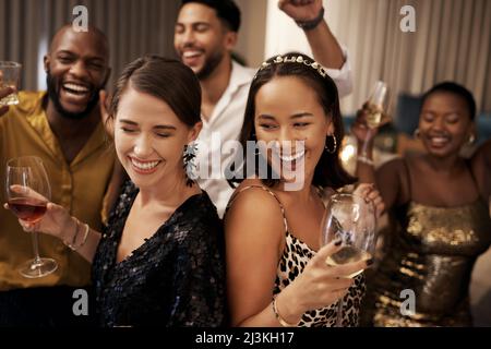 Wir planen, die ganze Nacht zu tanzen. Aufnahme einer vielfältigen Gruppe von Freunden, die während einer Neujahrsparty zu Hause tanzen. Stockfoto