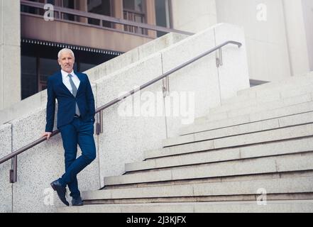 Ich bin für meinen eigenen Erfolg verantwortlich. Aufnahme eines selbstbewussten Geschäftsmannes, der vor seinem Bürogebäude in der Stadt steht. Stockfoto