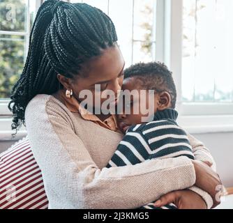 Ich hoffe, Sie fühlen sich bald besser. Aufnahme einer Frau, die ihren jungen Sohn zu Hause tröstet. Stockfoto