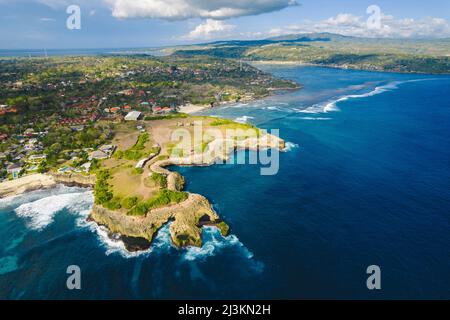 Luftaufnahme von Devil's Träne und der felsigen Küste von Nusa Lembongan mit dem türkisfarbenen Wasser des Bali Meeres, das gegen das Ufer stürzt Stockfoto