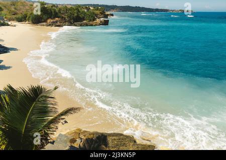 Türkisfarbenes Wasser und Meeresbrandung Rollen auf den Sandstrand von Lembongan vor der Küste von Bali; Nusa Islands, Klungkung Regency, Indonesien Stockfoto