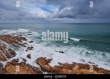 Blick vom Cape St Blaize Lighthouse auf die felsige Küste und den Atlantischen Ozean in der Mossel Bay entlang der Garden Route Stockfoto