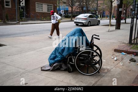 Georgia, USA. 08. April 2022. 8. April 2022, Atlanta, Georgia, USA: Eine obdachlose Frau, die behindert ist, huddelt unter einer Decke, während sie in ihrem Rollstuhl auf einem Bürgersteig in der Nähe der Georgia State University schläft (Bildquelle: © Robin Rayne/ZUMA Press Wire) Bildquelle: ZUMA Press, Inc./Alamy Live News Stockfoto