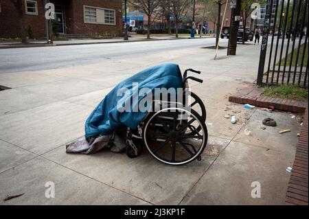 Georgia, USA. 08. April 2022. 8. April 2022, Atlanta, Georgia, USA: Eine obdachlose Frau, die behindert ist, huddelt unter einer Decke, während sie in ihrem Rollstuhl auf einem Bürgersteig in der Nähe der Georgia State University schläft (Bildquelle: © Robin Rayne/ZUMA Press Wire) Bildquelle: ZUMA Press, Inc./Alamy Live News Stockfoto