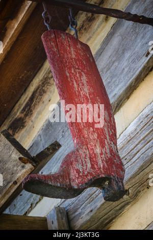 Schild mit einem verwitterten roten Holzstiefel draußen im Upper Canada Village; Morrisburg, Ontario, Kanada Stockfoto