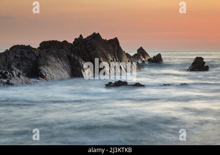 Ein Blick in die Dämmerung auf die Felsen der Atlantikküste, am Hartland Quay, Devon, England.; Hartland Quay, Devon, Großbritannien. Stockfoto