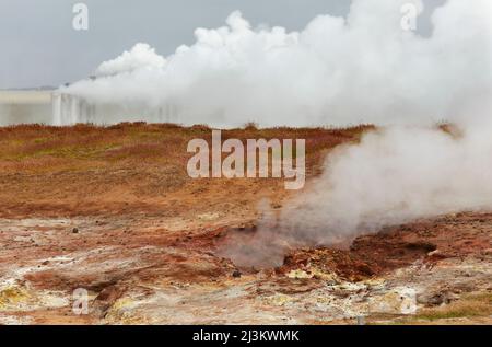 Gunnuhver Geothermiefeld, mit einer Geothermieanlage dahinter, Island.; Reykjanesviti, Halbinsel Reykjanes, Island. Stockfoto