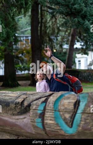 Vater und seine junge Tochter machen eine Pause, um die Natur zu erkunden, Horseshoe Bay, BC, Kanada; West Vancouver, British Columbia, Kanada Stockfoto