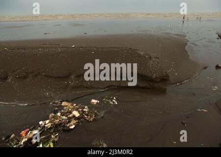 Würfe an einer kleinen Flussmündung, die aus Abwasser aus einem Abwasser am Pakis Beach in Pakis Jaya, Karawang, Indonesien gebildet wird. Stockfoto