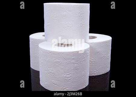 Toilettenpapierrollen auf schwarzem Hintergrund. Präsentation von Toilettenpapierrolle, isoliert auf schwarzem Hintergrund. Stockfoto