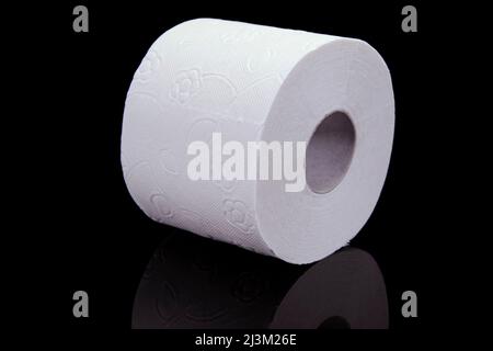 Toilettenpapierrolle auf schwarzem Hintergrund. Präsentation von Toilettenpapierrolle, isoliert auf schwarzem Hintergrund. Stockfoto