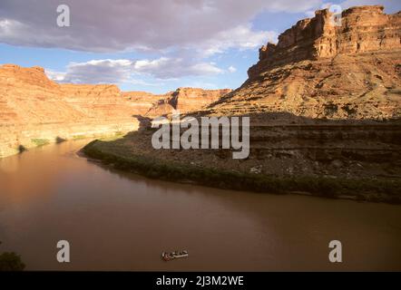 Ein Wildwasser-Floß schwimmt durch einen flachen Abschnitt des Colorado River.; Colorado River im Cataract Canyon, Utah. Stockfoto