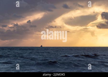 Schiff segelt über den Horizont in den Sonnenuntergang nach einem Sturm auf See; Brighton, East Sussex, England Stockfoto