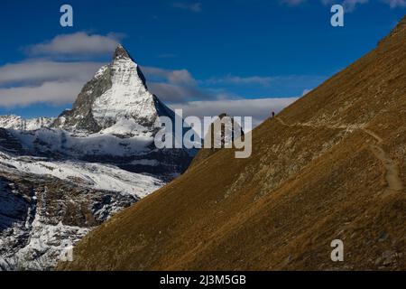 Trekking auf dem Weg neben dem Gornergletscher mit Blick auf das Matterhorn in der Ferne.; Gornergrat, Zermatt, Schweiz. Stockfoto
