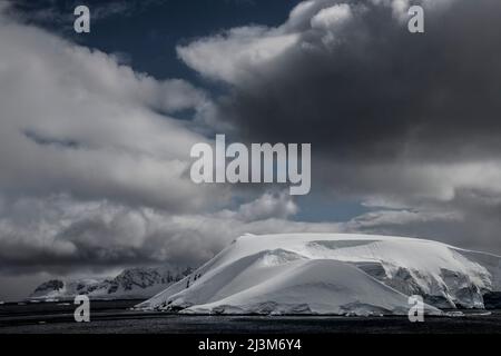 Dramatische Wolken rasten über dem Paradies-Hafen der Antarktis; Antarktis Stockfoto