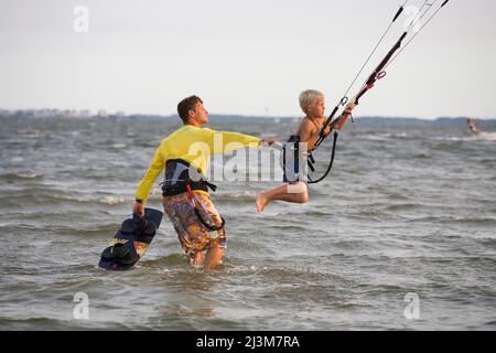 Kiteboarder Dad lehrt seinen sechsjährigen Sohn Kiteboard.; Nags Head, North Carolina. Stockfoto