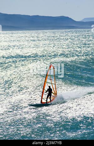 Windsurfsilhouette in der Sonne auf einer Welle vor Punta San Carlos.; Baja, Mexiko. Stockfoto