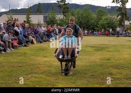 Ein Bruder und eine Schwester treten in einem Holzfällerrennen an. Ein Rückblick auf die Blütezeit der Holzindustrie, die Wettbewerbe bringen Kommunit... Stockfoto