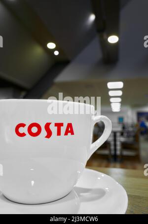 Tasse Costa-Kaffee auf einem Tisch während einer Kaffeepause an einer Tankstelle auf einer englischen Autobahn. Stockfoto