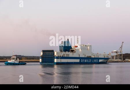 Cobh, Cork, Irland. 09.. April 2022. Nach einer Reise von Zeebrugge dampft die Fähre Eurpcargo Bari bei Sonnenaufgang den Fluss hinauf, begleitet vom Schlepper Gerry O' Sullivan, während sie ihren Weg zu ihrem Liegeplatz in Ringaskiddy, Co. Cork, Irland, macht. - Credit; David Creedon / Alamy Live News Stockfoto