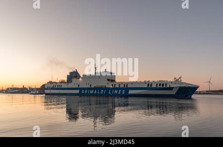 Cobh, Cork, Irland. 09.. April 2022. Nach einer Reise von Zeebrugge dampft die Fähre Eurpcargo Bari bei Sonnenaufgang den Fluss hinauf, begleitet vom Schlepper Gerry O' Sullivan, während sie ihren Weg zu ihrem Liegeplatz in Ringaskiddy, Co. Cork, Irland, macht. - Credit; David Creedon / Alamy Live News Stockfoto