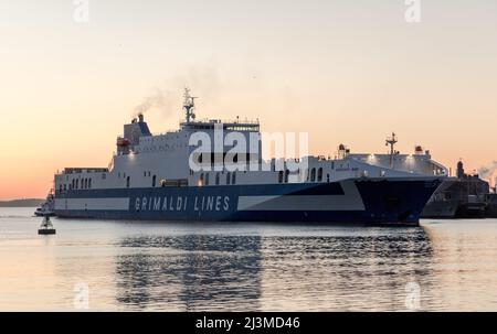 Cobh, Cork, Irland. 09.. April 2022. Nach einer Reise von Zeebrugge dampft die Fähre Eurpcargo Bari bei Sonnenaufgang den Fluss hinauf, begleitet vom Schlepper Gerry O' Sullivan, während sie ihren Weg zu ihrem Liegeplatz in Ringaskiddy, Co. Cork, Irland, macht. - Credit; David Creedon / Alamy Live News Stockfoto