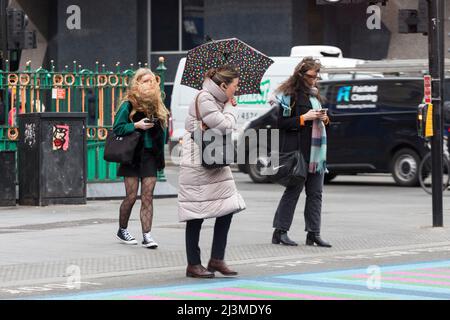 Das Wetter ist heute Morgen in London relativ trocken, mit gelegentlichen Nieseln, wenn Pendler am Morgen an der Tottenham Court Road und Oxford Circ vorbeifahren Stockfoto