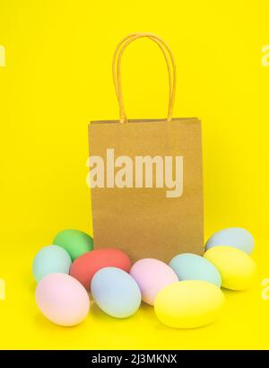 Papiertüte auf gelbem Hintergrund und ostereier. Speicherplatz kopieren Stockfoto