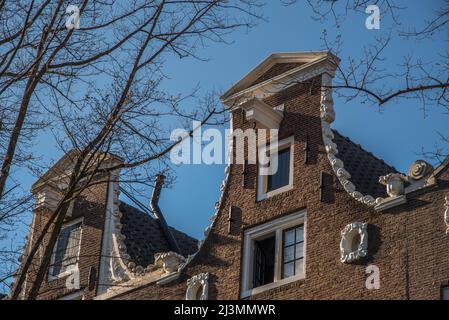 Amsterdam, Niederlande, April 2022. Historische Fassaden entlang der Grachten von Amsterdam. Hochwertige Fotos Stockfoto