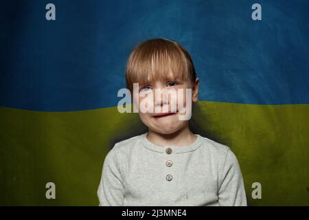 Angst Kind Mädchen weinen auf ukrainische Flagge Hintergrund. Stop Krieg in der Ukraine Konzept Stockfoto