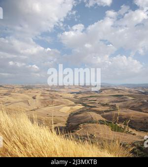 Weite Sicht auf goldenes Ackerland im sizilianischen Spätsommer und Wolkenlandschaft am Horizont Stockfoto