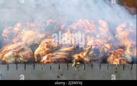 Nahaufnahme der Spieße beim Kochen auf dem Grill mit Rauch. Stockfoto