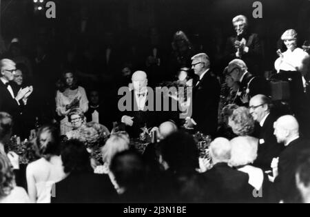 Regisseur ALFRED HITCHCOCK beobachtet von JAMES STEWART (ganz links) seine Frau ALMA REVILLE (in Brille sitzend) Und CARY GRANT hält seine Dankesrede, als er der siebte Empfänger des American Film Institute (AFI) war. Life Achievement Award am 7. 1979. März bei einer Feier im Beverly Hilton Hotel in Los Angeles Stockfoto